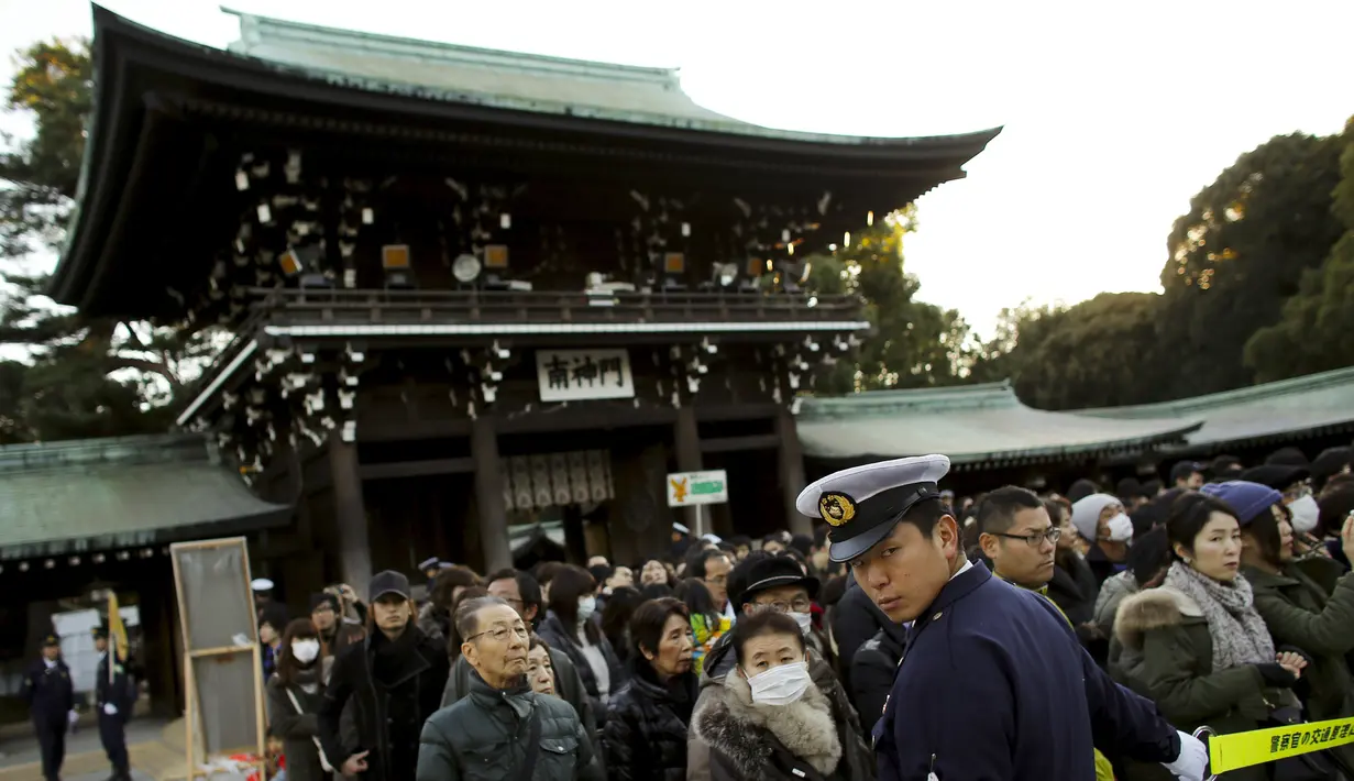 Petugas berjaga di pintu masuk gerbang Shinto Kuil Meiji di Tokyo, Jepang, (1/1/2015). Ribuan warga Jepang ingin berdoa dihari pertama tahun baru 2016. (REUTERS/Thomas Peter)