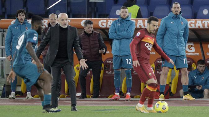 Penyerang AC Milan, Zlatan Ibrahimovic (kanan) menyaksikan rekan-rekannya bertanding melawan AS Roma pada pertandingan lanjutan Liga Serie A Italia di stadion Olimpiade, di Roma, Italia,Senin (1/3/2021). Saat ini AC MIlan mengemas 52 poin terpaut 4 poin dari Inter Milan. (AP Photo/Gregorio Borgia)