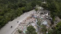 Rumah-rumah tergeletak di reruntuhan di sepanjang jalan yang rusak, empat hari setelah gempa berkekuatan 7,2 melanda bagian barat daya negara itu, di Rampe, Haiti, Rabu (18/8/2021). Korban jiwa akibat gempa di Haiti Sabtu pekan lalu terus bertambah menjadi 1.941 orang. (AP/Matias Delacroix)