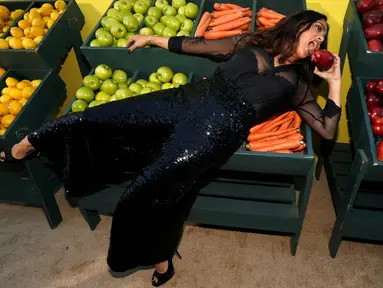 Artis Salma Hayek berpose sambil memegang buah apel saat menghadiri pemutaran perdana film "Sausage Party" di Los Angeles, California AS (9/8). Aktris 49 tahun ini mengisi suara Teresa Taco dalam film "Sausage Party". (REUTERS/Mario Anzuoni)