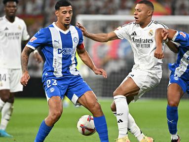 Penyerang Real Madrid, Kylian Mbappe (tengah) berebut bola dengan Alvaro Mourino dan Carlos Benavidez (Alaves) selama pertandingan sepak bola Liga Spanyol di stadion Santiago Bernabeu, Madrid, Selasa 24 September 2024 atau Rabu (25/9/2024) dini hari WIB. (JAVIER SORIANO/AFP)