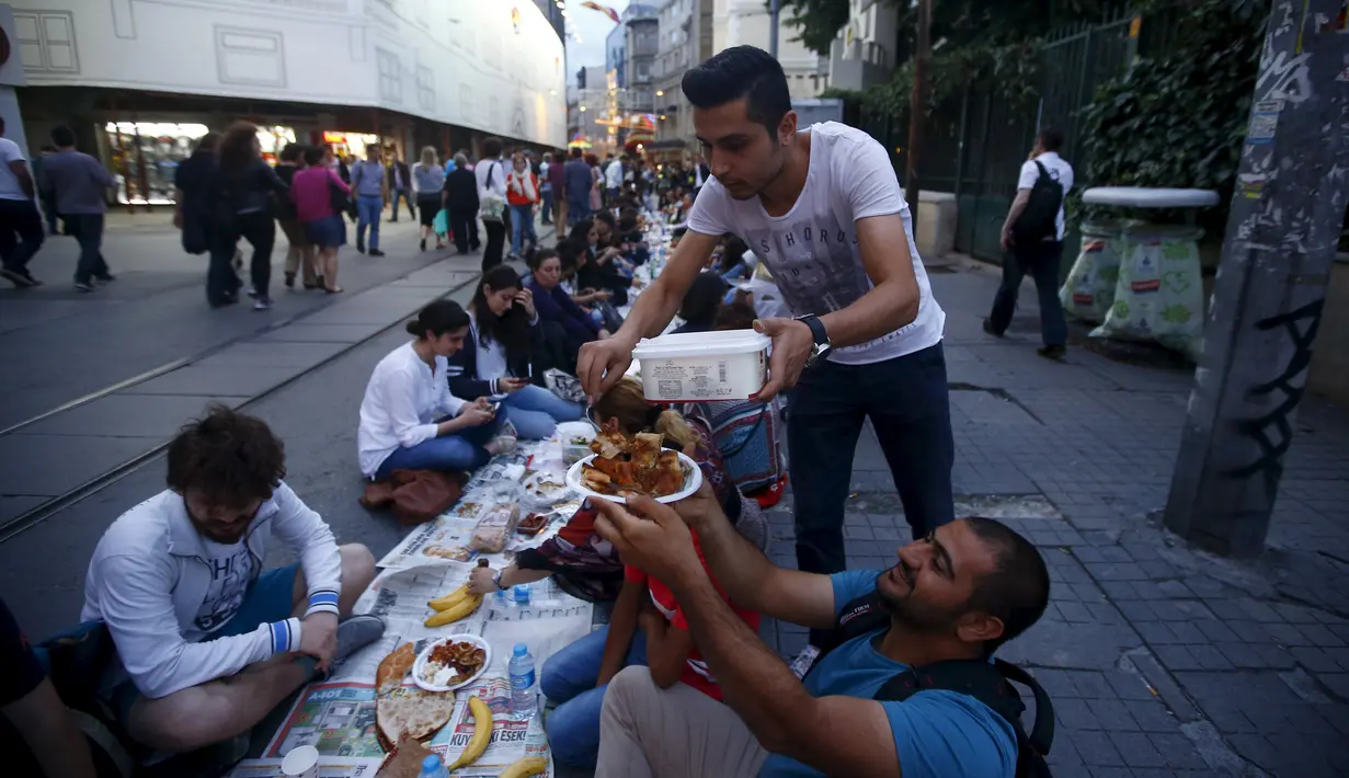 Warga saat bersiap menunggu waktu berbuka puasa pada hari pertama bulan suci Ramadan, di Taksim Square, Istanbul, Turki, Kamis (18/6/2015). Tradisi buka puasa beramai-ramai sudah menjadi tradisi di negara tersebut. (REUTERS/Osman Orsal)