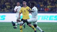 Gelandang Timnas Malaysia, Brendan Gan (kuning), berduel dengan striker Timnas Indonesia, Greg Nwokolo, di Stadion Nasional, Bukit Jalil (19/11/2019), dalam laga kelima Grup G kualifikasi Piala Dunia 2022 zona Asia. (AFP/STR)