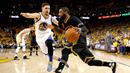 Pebasket Cleveland Cavaliers, Kyrie Irving, berusaha melewati pebasket Golden State Warriors, Klay Thompson pada gim ketujuh final NBA. Irving menjadi penentu keunggulan Cavs melalui tembakan tiga angka. (AFP/Ezra Shaw)