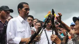 Saat melihat keadaan pasar, Jokowi ditawari tikus bakar oleh seorang pedagang di Pasar Tomohon, Sulawesi Utara, Sabtu (10/5/2014) (Liputan6.com/Herman Zakharia).