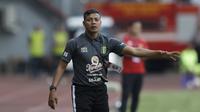 Pelatih Persebaya Surabaya, Bejo Sugiantoro, memberikan arahan saat melawan Bhayangkara FC pada laga Shopee Liga 1 di Stadion Patriot Chandrabhaga, Bekasi, Sabtu (31/8). (Bola.com/Yoppy Renato)
