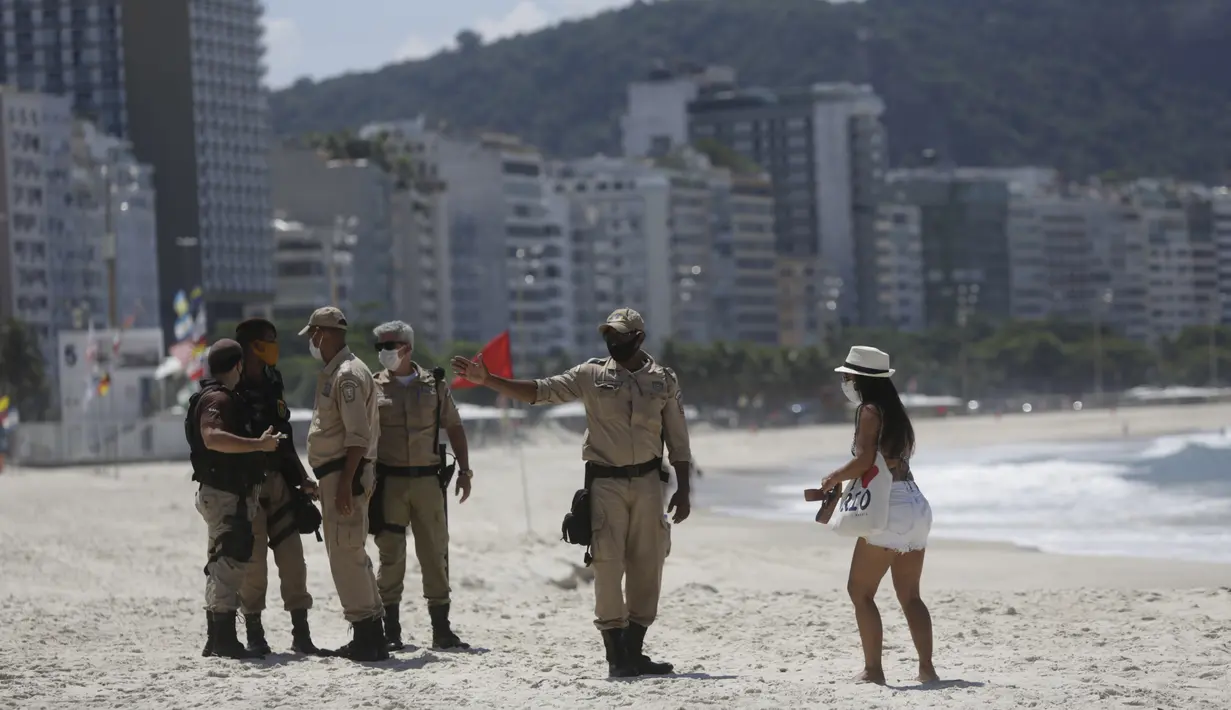 Polisi menjauhkan pengunjung dari pantai Arpoador yang ditutup karena diberlakukannya kembali pembatasan pandemi COVID-19 di Rio de Janeiro, Brasil, Sabtu (20/3/2021). Rio de Janeiro menutup pantai-pantainya yang terkenal untuk menekan angka kasus virus corona. (AP Photo/Bruna Prado)