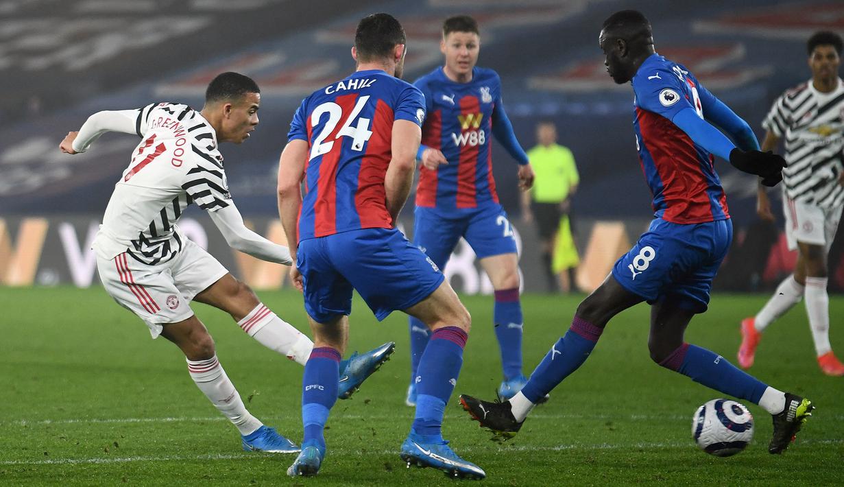 Striker Manchester United, Mason Greenwood (kiri) melepakan tendangan yang berhasil diblok pemain Crystal Palace dalam laga lanjutan Liga Inggris 2020/21 pekan ke-27 di Selhurst Park, Rabu (3/3/202). Manchester United bermain imbang 0-0 dengan Crystal Palace. (AFP/Mike Hewitt/Pool)
