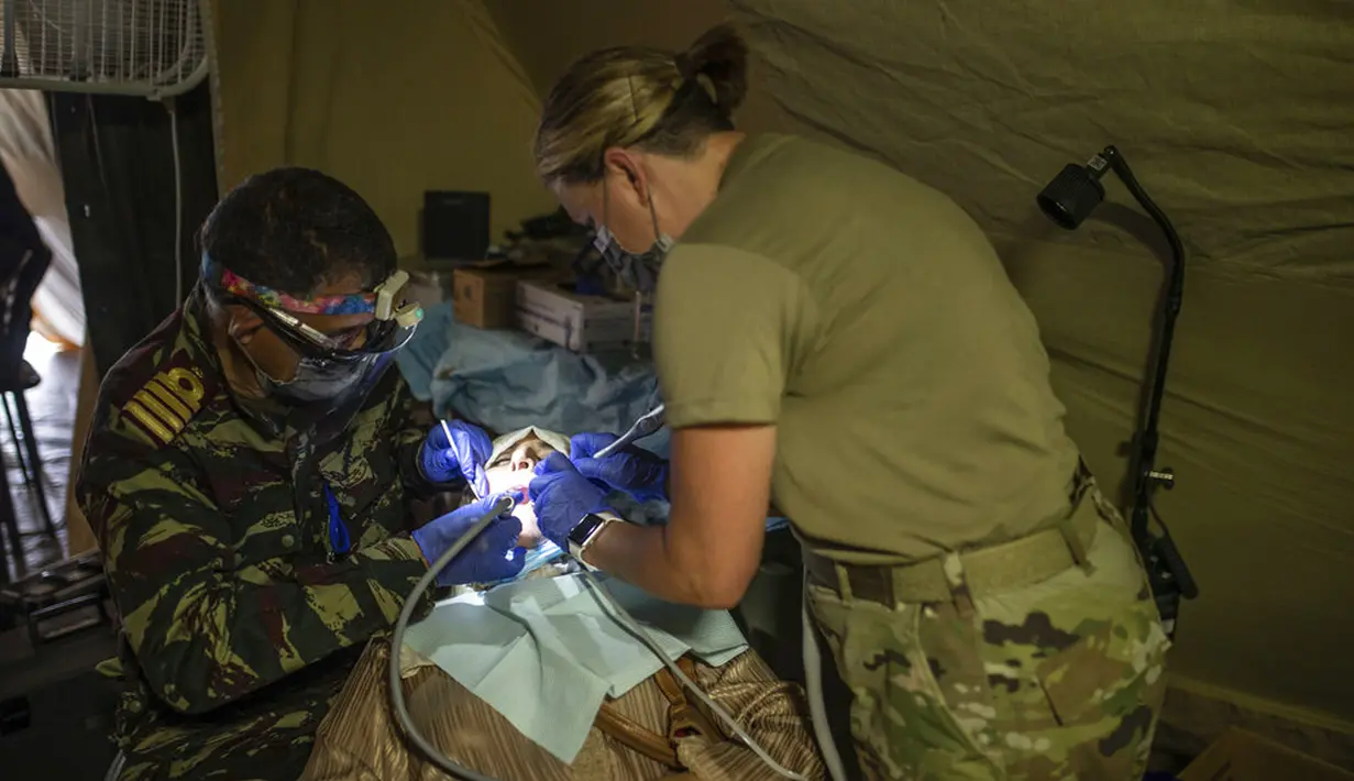 Dokter gigi militer AS dan Maroko mengoperasi wanita di rumah sakit lapangan militer selama latihan militer Singa Afrika di Tafraout, Maroko, Kamis (10/6/2021). Dengan lebih 7.000 peserta dari 9 negara dan NATO, Singa Afrika adalah latihan terbesar Komando Afrika AS. (AP Photo/Mosa'ab Elshamy)