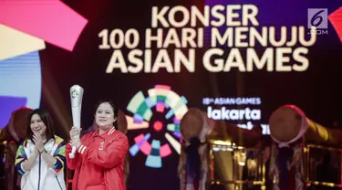 Menko PMK Puan Maharani disaksikan Susi Susanti memegang obor untuk Asian Games 2018 saat peluncuran Torch Asian Games dalam konser 100 Hari Menuju Asian Games 2018 di Studio 6 Emtek, Jakarta, Kamis (10/5). (Liputan6.com/Faizal Fanani)