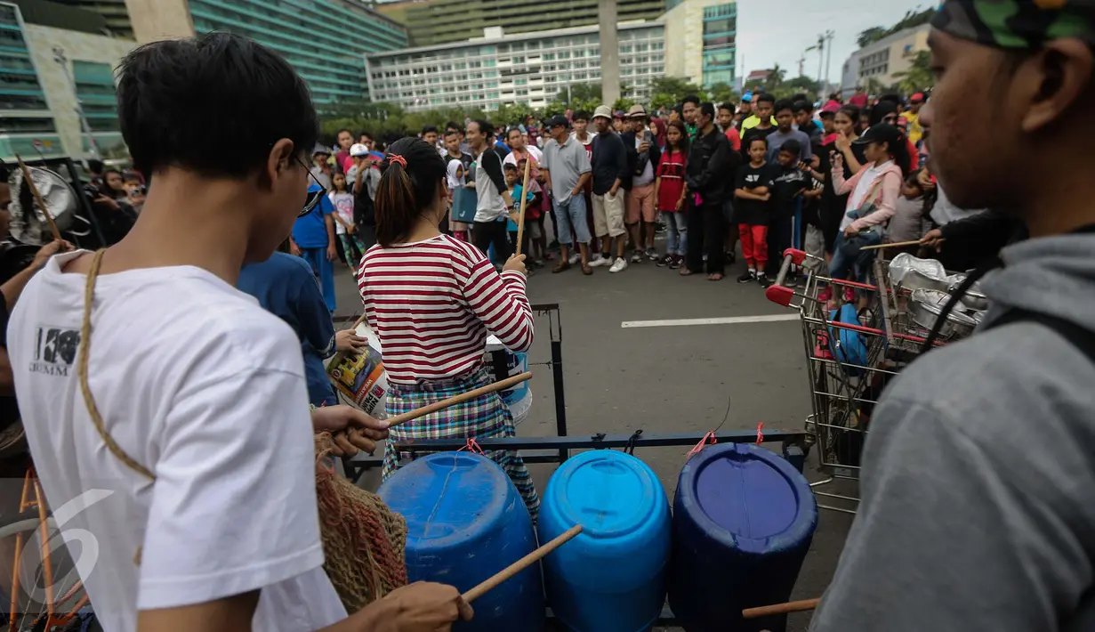 Kreatifitas mahasiswa dalam bermusik dengan alat musik dari barang bekas sangat menghibur warga yang beraktifitas di Car Free Day Bundaran HI, Jakarta, Minggu (15/1). (Liputan6.com/Faizal Fanani)