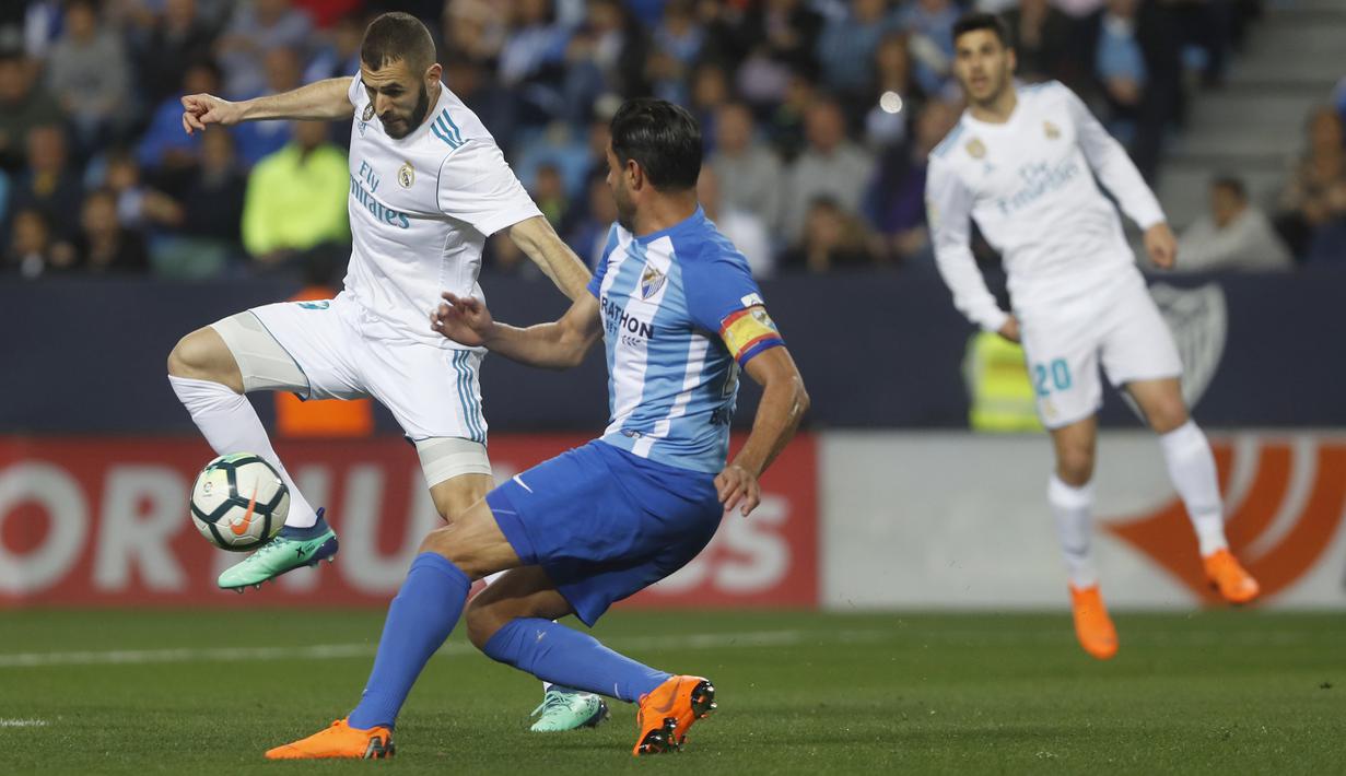 Pemain Real Madrid, Karim Benzema mencoba melewati adangan pemain Malaga pada lanjutan La Liga Santander di Rosaleda stadium, Malaga, (15/4/2018). Madrid menang 2-1. (AP/Miguel Morenatti)