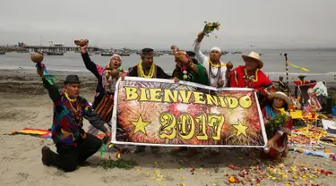 Sejumlah dukun asal Peru membentangkan poster prediksi ramalan jelang pergantian tahun di Pantai Agua Dulce di Lima, Peru, (29/12). Para dukun tersebut meramalkan tahun 2017. (Reuters/Mariana Bazo)