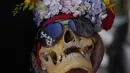 Seorang wanita membawa tengkorak yang dihias di pemakaman umum selama festival tahunan "Natitas" di La Paz, Bolivia, Senin (8/11/2021). Dalam festival ini warga ramai-ramai menghias tengkorak leluhur mereka dengan berbagai dekorasi mulai dari bunga, kacamata dan hiasan lainnya (AP Photo/Juan Karita)