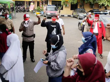 Petugas kepolisian berpakaian pejuang jaman dulu saat memberikan pengarahan kepada warga yang akan ikut vaksin Covid-19 di Polsek Pasar Rebo, Jakarta, Selasa (17/8/2021). Para petugas berkostum pejuang jaman dulu memeriahkan HUT ke-76 Republik Indonesia. (Liputan6.com/Angga Yuniar)