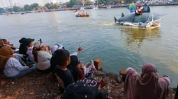 Sejumlah warga menyaksikan parade perahu hias dalam Festival Perahu Cinta Lingkungan (CiLung Fest) 2026 di Waduk Sunter Selatan, Tanjung Priok, Jakarta Utara, Minggu (18/10/2026). (KLY/Budy Santoso)