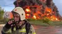 Foto dari Gubernur Sevastopol, Mikhail Razvozhaev, dari Telegram. Seorang pemadam kebakaran memantau kebakaran di tanki bahan bakar di Crimea pada Sabtu (29/4). Dok: Channel Telegram Gubernur Sevastopol Mikhail Razvozhaev via AP