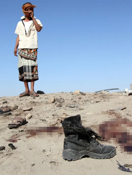 Seorang tentara mengamati lokasi bom bunuh diri di sebuah pangkalan militer kota Aden, Yaman, Minggu (18/12). Insiden ini terjadi satu pekan setelah militan ISIS melakukan serangan yang menewaskan 50 tentara Yaman. (SALEH AL-OBEIDI/AFP)