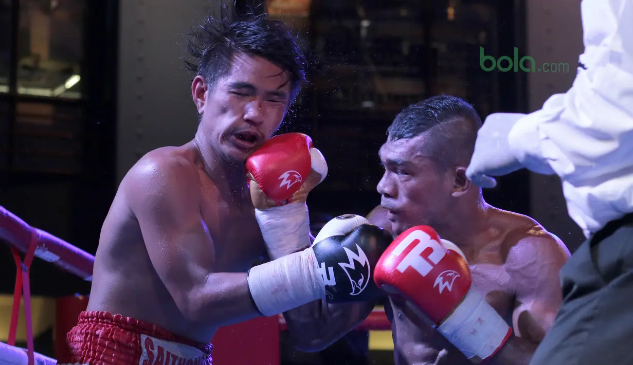 Jansen Marapu (kanan) melepaskan pukulan ke wajah Phuttiphong Rakoon pada kelas Lightweight Mahkota Boxing Super Series di Cilandak Town Square, Jakarta (10/3/2018). Jansen menang TKO ronde ke sembilan. (Bola.com/Nick Hanoatubun)