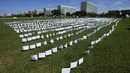 Bendera putih menutupi lapangan sebagai bagian dari protes terhadap kebijakan kesehatan pemerintah di luar Kongres di Brasilia, Jumat (15/10/2021). Sebanyak 600 bendera, masing-masing dengan nama seseorang, mewakili 600.000 korban yang telah meninggal COVID-19 di Brasil. (AP Photo/Eraldo Peres)