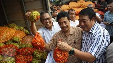 Dirut Bulog, Djarot Kusumayakti (kiri) mengangkat cabai saat operasi pasar di Pasar Induk Kramat Jati, Jakarta, Sabtu (15/8/2015). Operasi pasar ini untuk menekan kenaikan harga cabai yang mencapai Rp 70.000/kg. (Liputan6.com/Gempur M Surya)