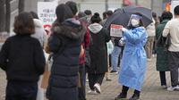 Pekerja medis memegang tanda bagi pengunjung untuk tes virus corona di klinik skrining sementara di Seoul, Korea Selatan, Jumat (10/12/2021). Otoritas kesehatan Korea Selatan melaporkan lebih dari 7.000 kasus COVID-19 baru untuk ketiga hari berturut-turut pada hari Jumat ini. (AP Photo/Lee Jin-man)