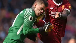 Kaki Mane menghantam tepat di wajah kiper Manchester City, Ederson saat pertandingan Liga Inggris di Stadion Etihad, Manchester (9/9). Usai hantaman, Ederson langsung mendapat perawatan hingga ditandu ke luar lapangan. (AFP Photo/Oli Scarff)