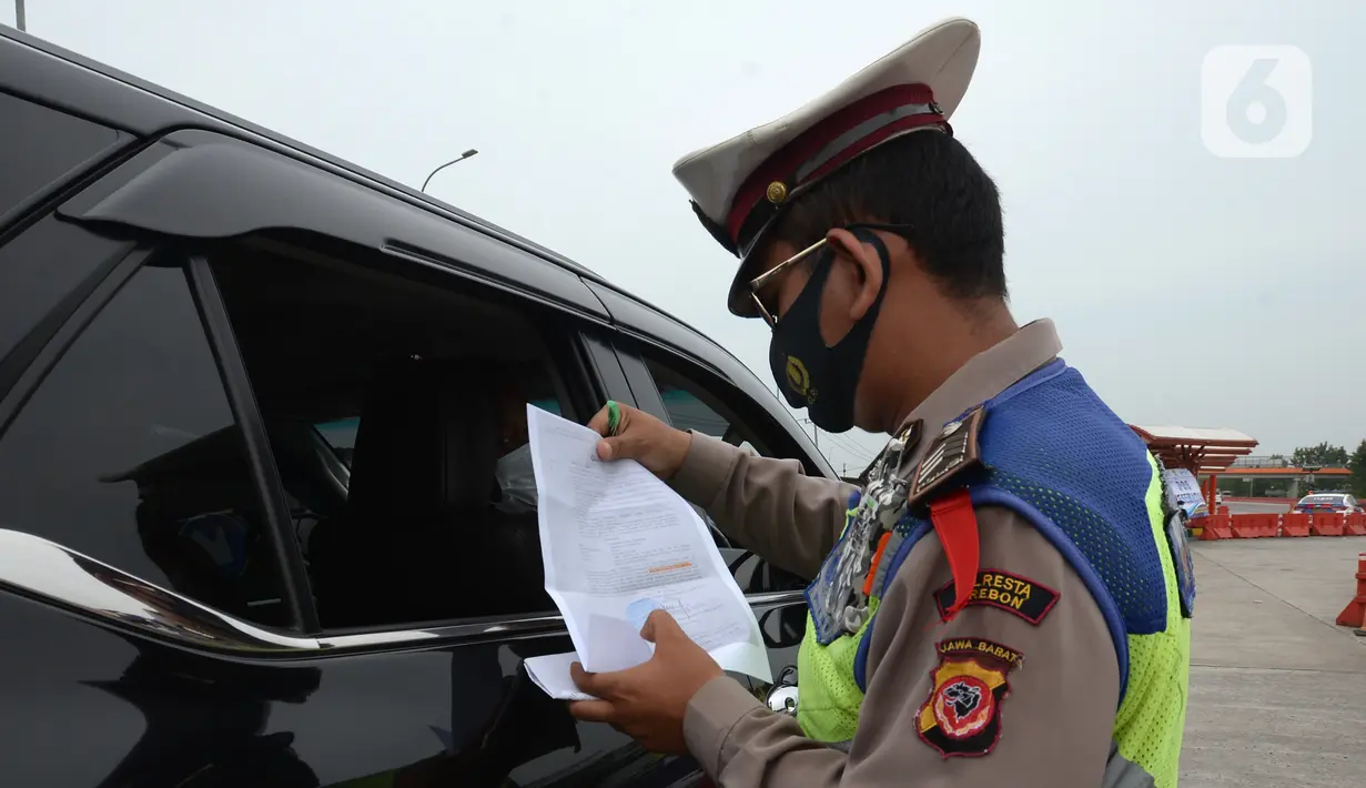 Polisi memeriksa kendaraan di Gerbang Tol Palimanan, Jakarta, Jumat, (7/5/2021). Gerbang Tol Palimanan terpantau sepi pemudik dan didominasi oleh kendaraan angkutan barang pada hari kedua penyekatan. (merdeka.com/Imam Buhori)