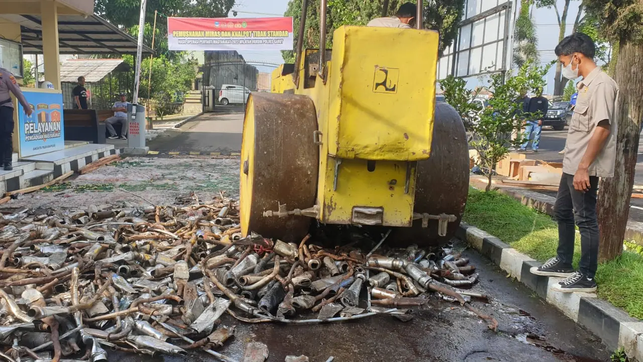 Menjelang libur natal dan tahun baru (Nataru), Kepolisian Resort Garut, Jawa Barat, memusnahkan ribuan botol minuman keras dan ratusan knalpot tak berstandar di lapangan Mapolres Garut, Jumat pagi.(Liputan6.com/Jayadi Supriadin)`