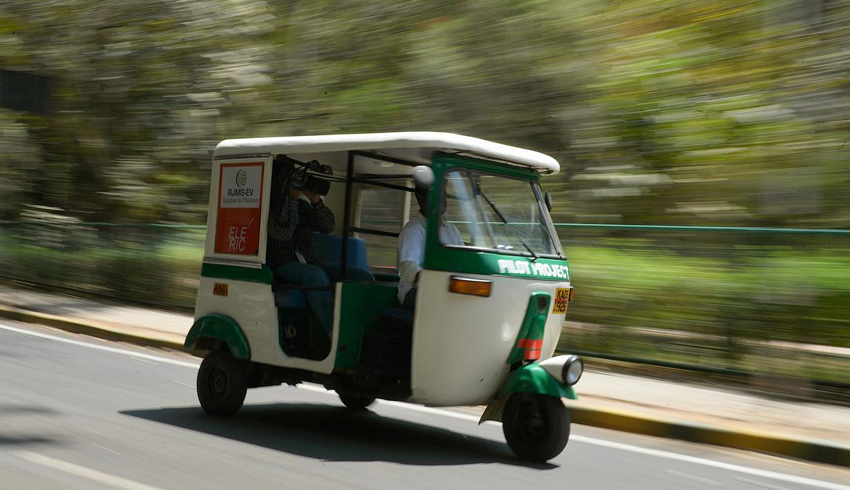 Bajaj 'Eleric-Auto' saat mengangkut seorang kamerawan di Bangalore, India, Sabtu (5/3). Di India 20 persen masyarakatnya menggunakan transportasi umum untuk berpergian dan Bajaj 'Eleric-Auto' salah satunya. MANJUNATH KIRAN / AFP)