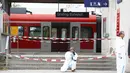 Polisi mengambil gambar di lokasi penyerangan di stasiun kereta komuter S-Bah di Grafing, kota di Munich, Jerman selatan, Selasa (10/5). Penikaman yang dilakukan seorang pria berusia 27 tahun itu dilaporkan menewaskan satu orang. (REUTERS/Michaela Rehle)
