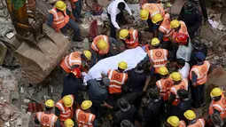 Petugas penyelamat menggotong salah satu korban runtuhnya sebuah bangunan runtuh, Mumbai, India, Selasa (4/8/2015). Bangunan tersebut runtuh karena kondisinya yang sudah tak layak pakai dan menewaskan 11 orang.(REUTERS/Danish Siddiqui)