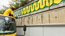 Pasukan Kuning mengecat dinding Underpass Kebayoran Baru, Jakarta Selatan, Kamis (1/2). Pasukan Kuning berada di bawah naungan Dinas Bina Marga Pemerintahan Provinsi DKI Jakarta. (Liputan6.com/Immanuel Antonius)
