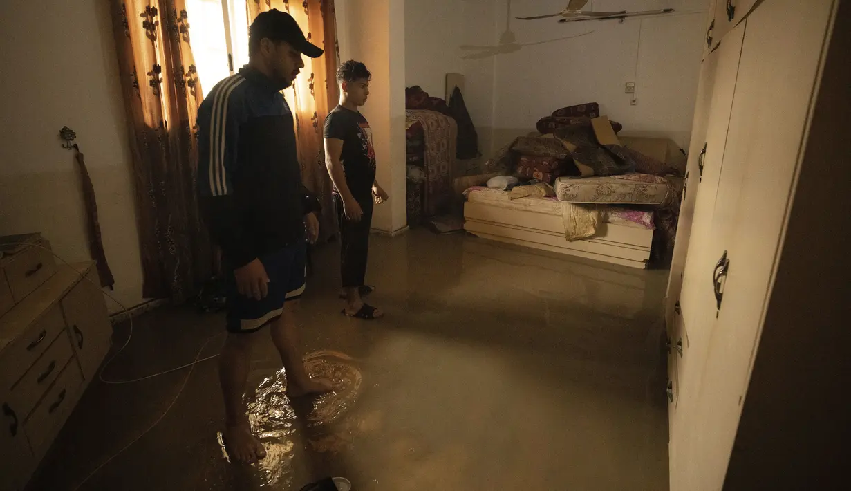 Warga memeriksa beberapa barang keluarga mereka dari kamar tidur rumahnya yang terendam banjir saat hujan deras di kamp pengungsi Shati, di Kota Gaza, Selasa (8/11/2022). Hujan deras menyebabkan banjir bandang di Jalur Gaza pada hari Selasa, di mana infrastruktur yang bobrok sering membuat air banjir tidak surut, memperpanjang kerusakan. (AP Photo/Adel Hana)