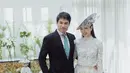 Nong Poy memilih gaun pengantin dengan atasan renda warna putih dan rok aksen ruffle. Ia mengenakan aksesori fascinator ala keluarga kerajaan.  [@niyadarweddinganswer]