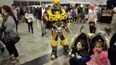 Peserta mengenakan kostum robot bumblebee dalam film 'Transformers' saat mengikuti festival cosplay di Sydney, Australia, Minggu (15/6/14). (AFP PHOTO/Peter Parks)