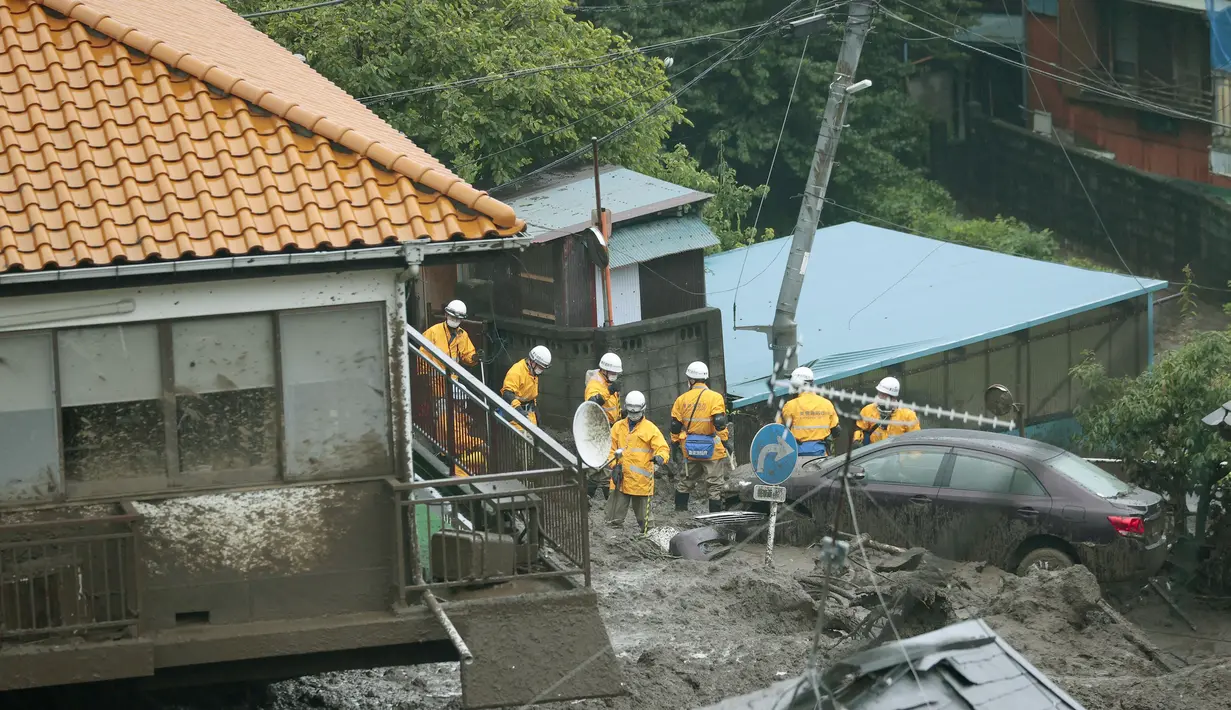 Tim penyelamat bekerja saat mereka melakukan operasi pencarian di lokasi tanah longsor di Atami, prefektur Shizuoka, Tokyo, Minggu (4/7/2021). Evakuasi korban hilang masih terus dilakukan menyusul bencana tanah longsor dipicu oleh hujan lebat yang menewaskan dua orang tersebut. (Kyodo News via AP)