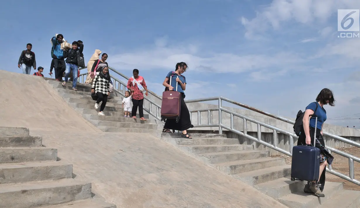 Wisatawan melintasi tangga tanggul laut yang telah selesai dibangun di Pelabuhan Kali Adem, Muara Angke, Jakarta, Selasa (12/2). Pembangunan tanggul laut tersebut memiliki tinggi 4 meter. (Merdeka.com/Iqbal S. Nugroho)