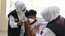 Reaksi seorang siswa SMA saat menerima dosis vaksin virus corona COVID-19 Pfizer di Rumah Sakit Zainoel Abidin, Banda Aceh, Aceh, Selasa (9/11/2021). Vaksinasi COVID-19 di kalangan warga Kota Banda Aceh tembus 80 persen. (CHAIDEER MAHYUDDIN/AFP)