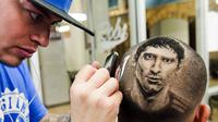 Salah satu suporter Argentina membuat lukisan wajah Lionel Messi di rambutnya di sebuah salon di San Antonio, Texas, (30/6/2014). (REUTERS/Ashley Landis)