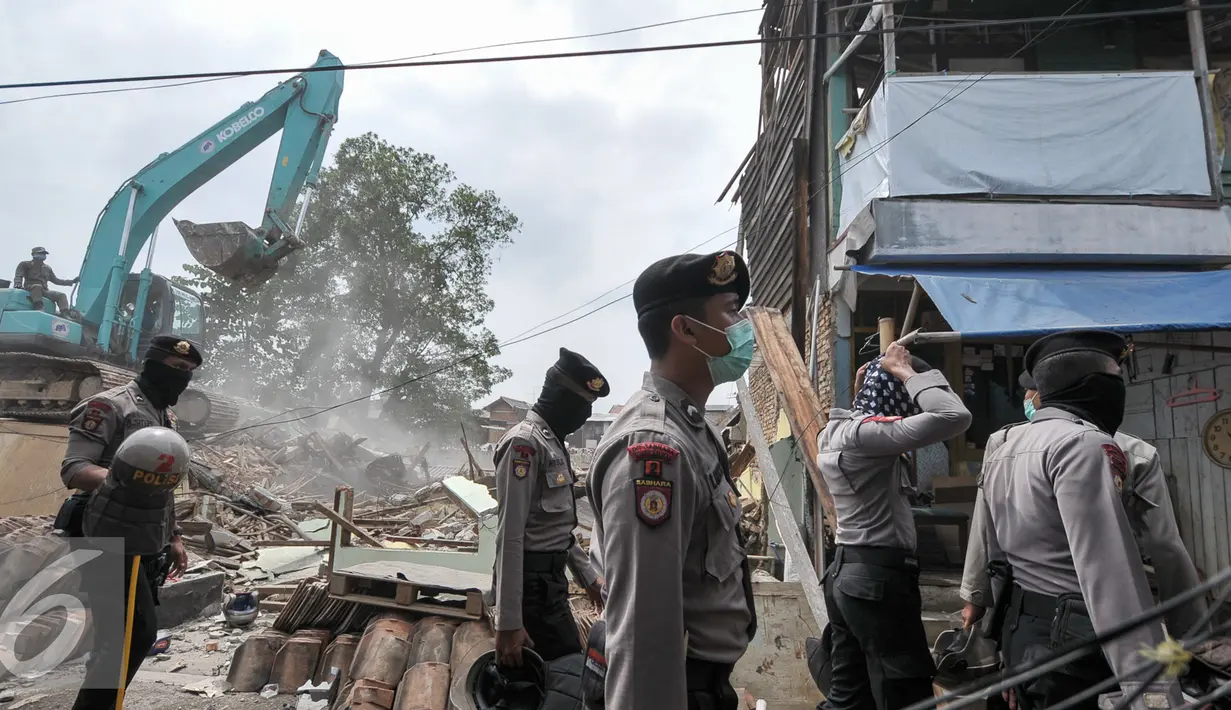 Sejumlah petugas ikut mengamankan proses penggusuran permukiman di bantaran Kali Ciliwung Jakarta, Rabu (28/9). Pemprov DKI meratakan pemukiman warga Bukit Duri dan Sanggar Ciliwung Merdeka terkait revitalisasi sungai Ciliwung. (Liputan6.com/Yoppy Renato)