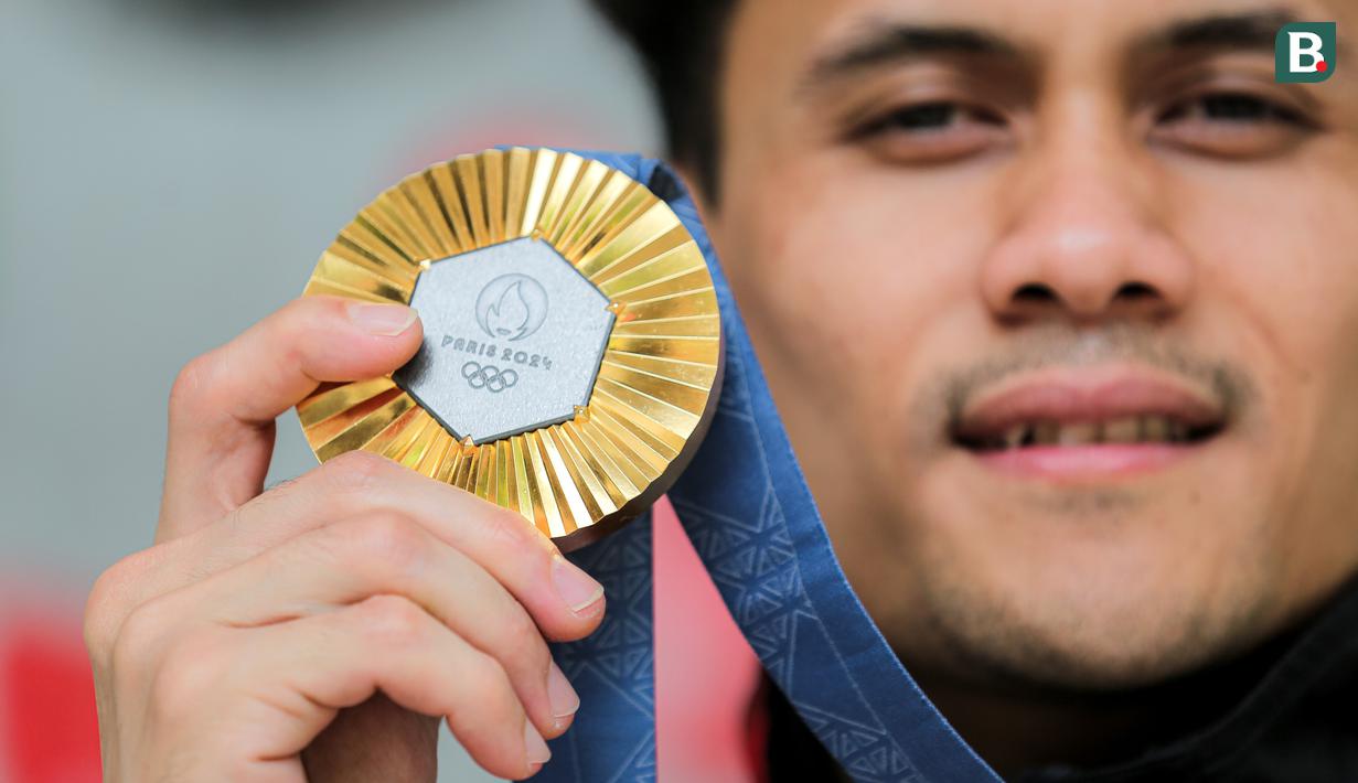 <p>Atlet panjat tebing Indonesia, Veddriq Leonardo menunjukkan medali emas Olimpiade Paris 2024 di markas FPTI, Hotel Santika Premier, Bekasi, Selasa (20/08/2024). (Bola.com/Bagaskara Lazuardi)</p>