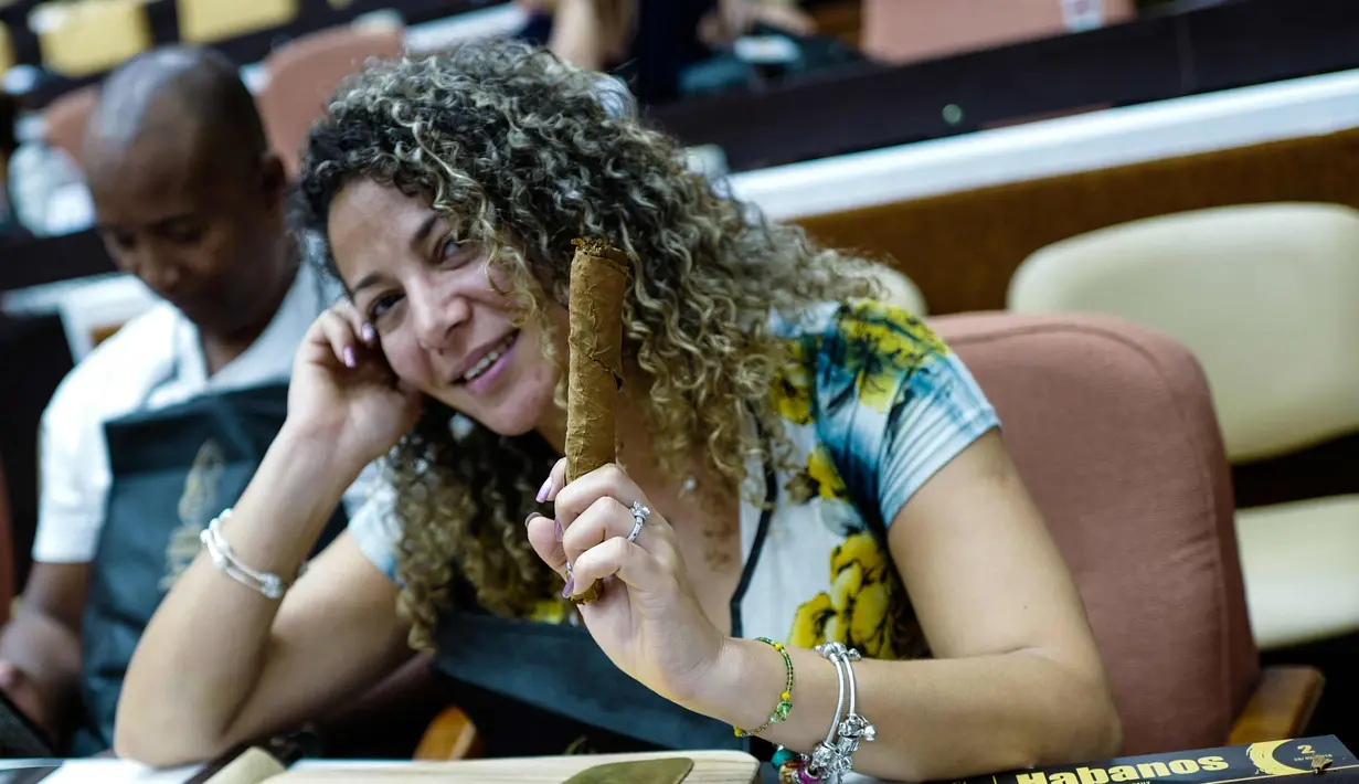 Peserta wanita menunjukkan cerutu yang dibuatnya selama kelas master dalam Festival Havana Cigar ke-20 di Istana Konvensi di Havana, Kuba (28/2). (AFP Photo/Adalberto Roque)