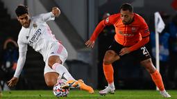 Penyerang Real Madrid, Marco Asensio, berebut bola dengan gelandang Shaktar Donetsk, Maycon, pada laga Liga Champions 2020/2021 di Estadio Alfredo Di Stefano, Rabu (21/10/2020) malam WIB. Real Madrid kalah 2-3 oleh Shaktar Donetsk. (AFP/Gabriel Bouys)