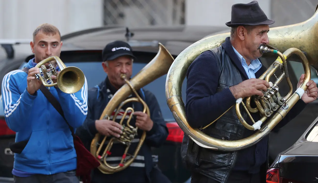 Aksi orkes tiup musisi Rumania untuk mendapat uang di jalanan Warsawa, Polandia pada 21 Oktober 2019. Orkes tiup yaitu sekelompok orang yang memperagakan musik dengan menggunakan instrumen musik tiup baik tiup logam maupun tiup kayu.  (AP Photo/Czarek Sokolowski)