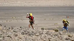 Peserta meminum air saat mengikuti kejuaraan Marathon des Sables ke-32 tahap ketiga di Gurun Sahara, selatan Maroko, Selasa (11/4). Salah satu kompetisi paling berat itu menjadi ajang tahunan sejak 1986 di setiap bulan April. (JEAN-PHILIPPE KSIAZEK/AFP)