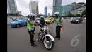 Mulai hari Minggu (18/1/2015), petugas kepolisian memberikan sanksi berupa denda senilai Rp 500 ribu bagi pemotor yang nekat melintasi Jalan MH Thamrin-Medan Merdeka Barat, Jakarta. (Liputan6.com/Miftahul Hayat)