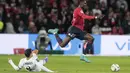 Gelandang Lille Amadou Onana ditekel oleh gelandang Paris Saint-Germain (PSG) Leandro Paredes dalam lanjutan Liga Prancis di Stadion Pierre-Mauroy, Senin (7/2/2022) dinihari WIB. PSG mengalahkan juara bertahan Lille dengan skor 5-1. (AP Photo/Michel Spingler)