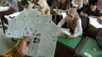 Seorang pengawas mengecek daftar hadir peserta tes calon pegawai negeri sipil (CPNS) di SMA Negeri 2 Jember, Jawa Timur. (Antara)