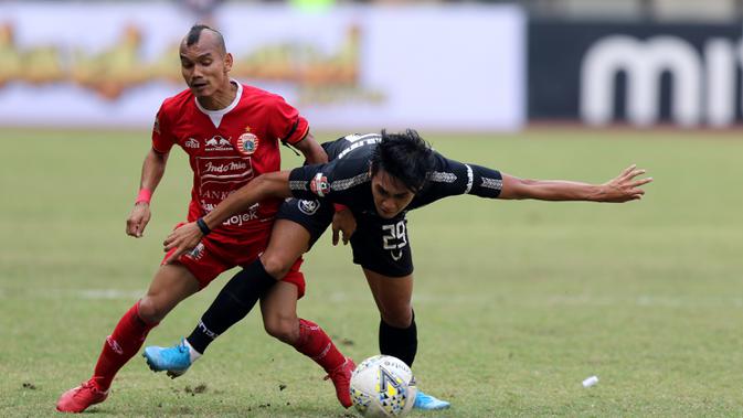 Gelandang Persija Jakarta, Riko Simanjuntak, berebut bola dengan gelandang PSIS Semarang, Septian David, pada laga Liga 1 di Stadion Patriot, Bekasi, Minggu (15/9). Persija menang 2-1 atas PSIS. (Bola.com/M Iqbal Ichsan)